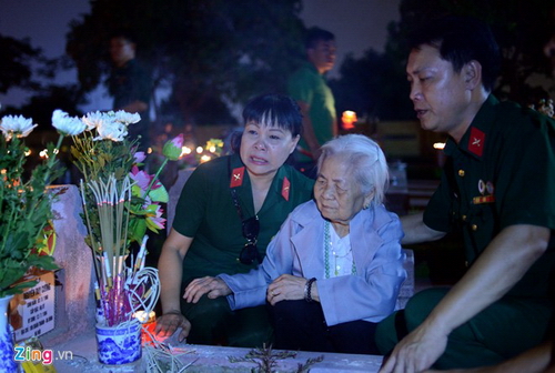 Chị Kim Thanh (đội tuyên văn) thuộc đại đội 12, tiểu đoàn 3, Sư đoàn 356 cùng mẹ của liệt sĩ Nguyễn Duy Cường - bà Nguyễn Thị Bé đã không kìm được nước mắt khi ngồi trước phần mộ của ông.